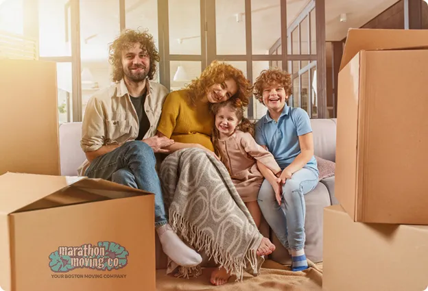 A happy family sitting among moving boxes in their new home