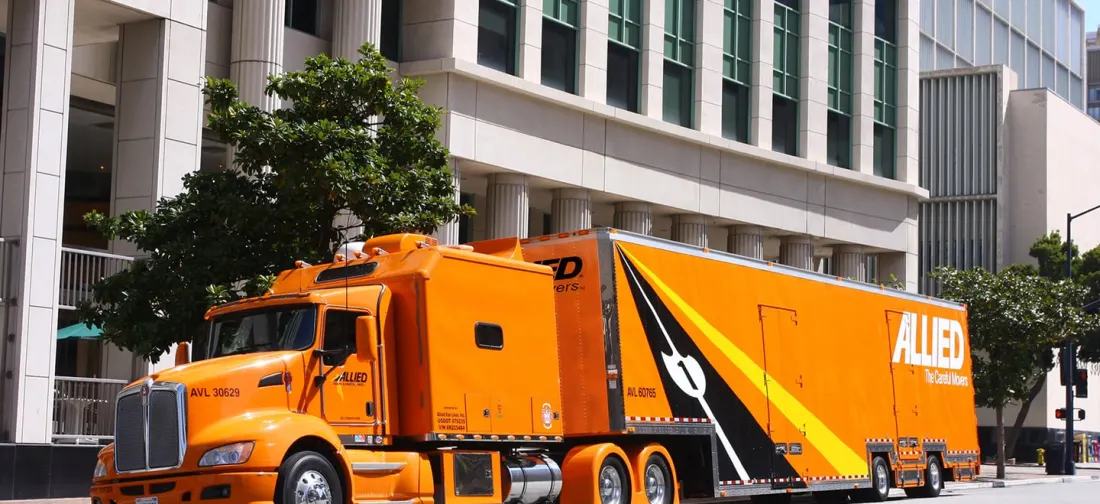 Orange Allied moving truck parked on a city street